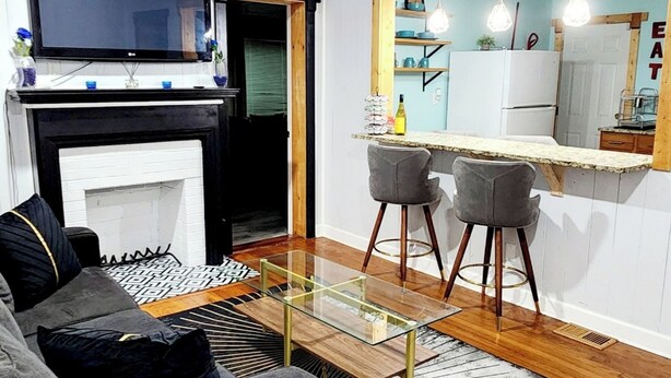Un salon moderne avec un canapé, une table basse en verre et une cheminée.