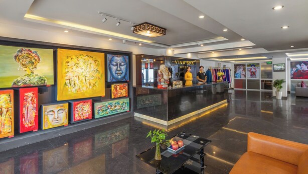 A hotel lobby with a reception desk, artwork on the walls, and seating areas. - Vina Spa Hotel (Hue)
