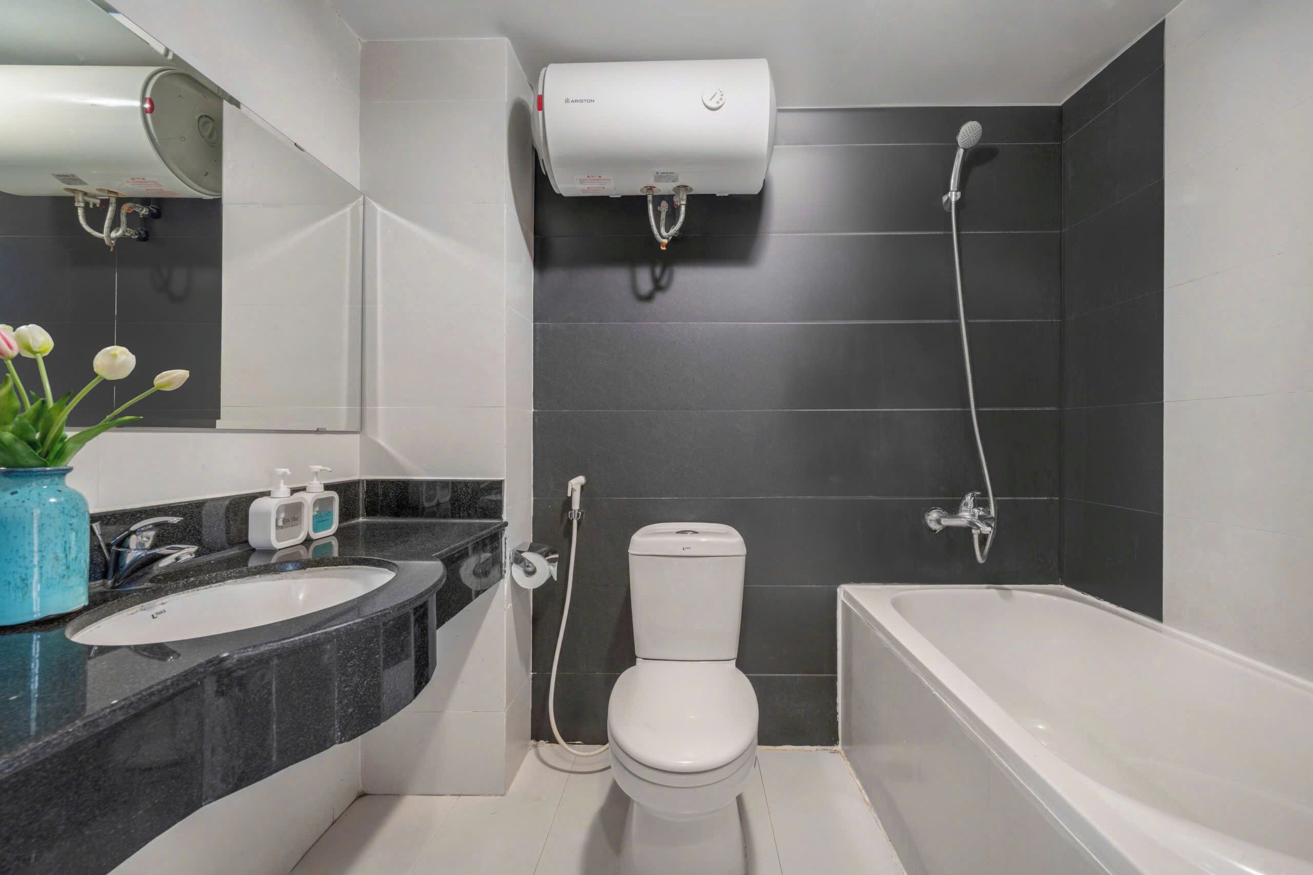A modern bathroom with a bathtub, toilet, and a sink.