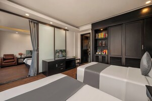 Ett modernt hotellrum med en säng, ett skrivbord, en tv och en garderob.