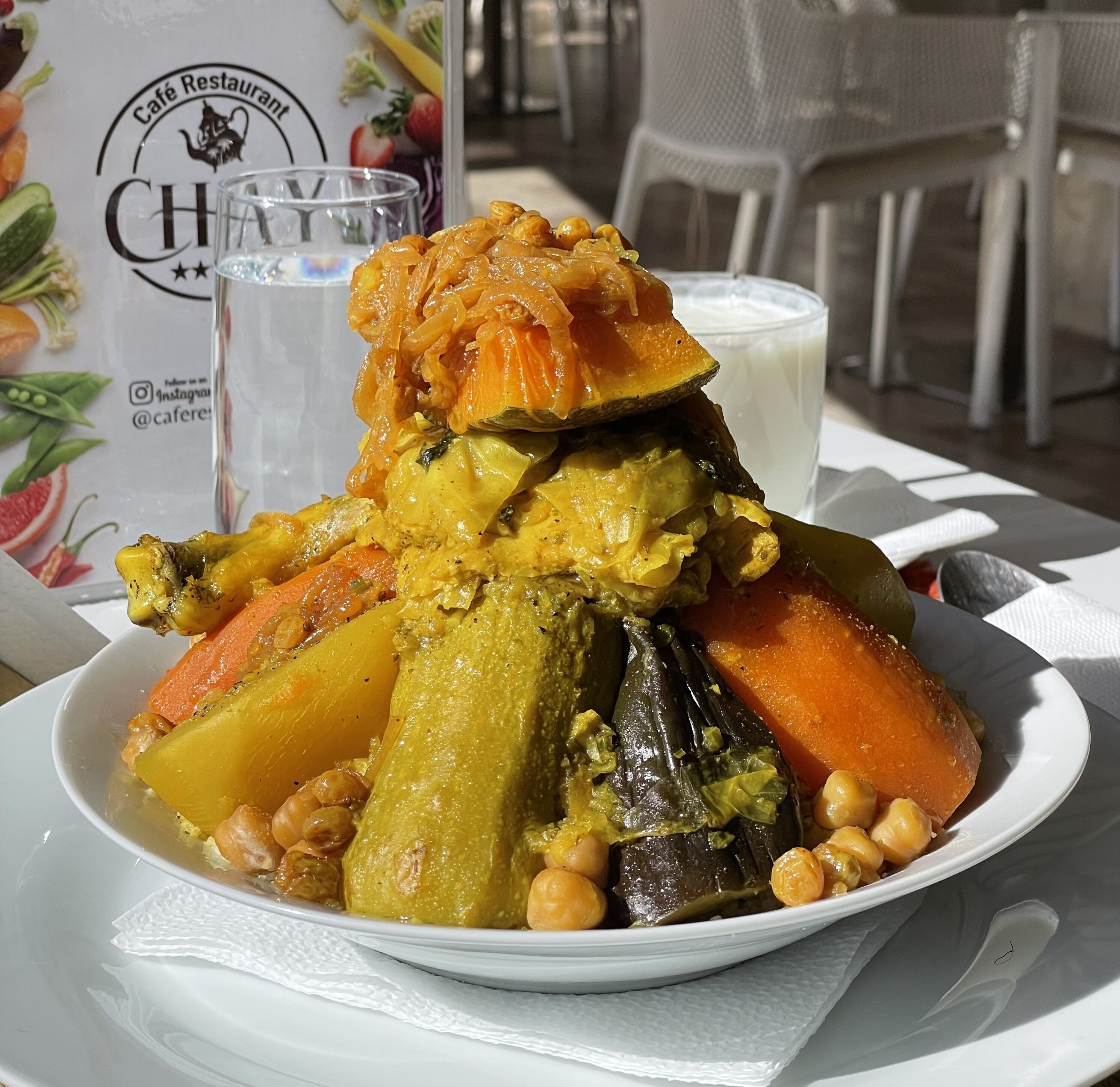 Un plato de estofado de verduras con garbanzos, zanahorias y patatas, servido en un plato blanco.