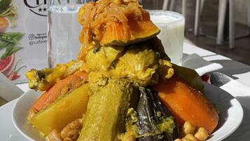 A plate of vegetable stew with chickpeas, carrots, and potatoes, served on a white plate.