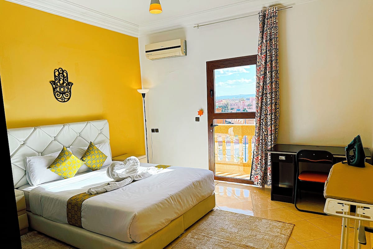 Una habitación de hotel con una cama, un escritorio y vista a la ciudad.
