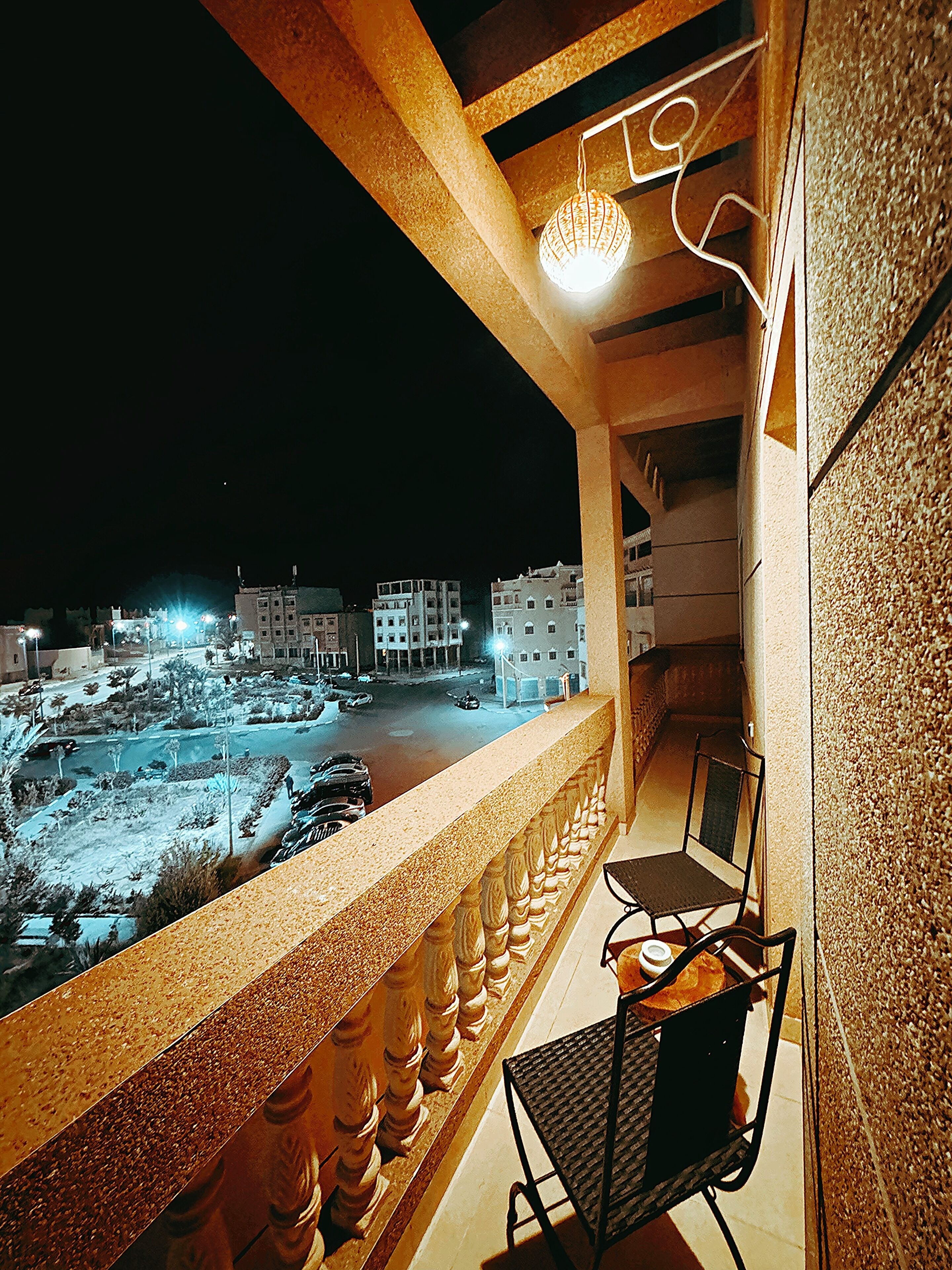 A balcony with a view of a cityscape at night.