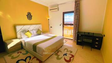 Ein Hotelzimmer mit Bett, Schreibtisch und Blick ins Freie.