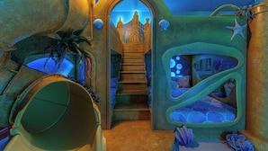 Ein fantastisches Unterwasser-Themenzimmer mit einer Wendeltreppe, die zu einer schlossartigen Struktur führt.