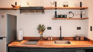 A modern kitchen with wooden countertops, a stainless steel sink, and a built-in range hood. - Ananta Dome (Monteverde)