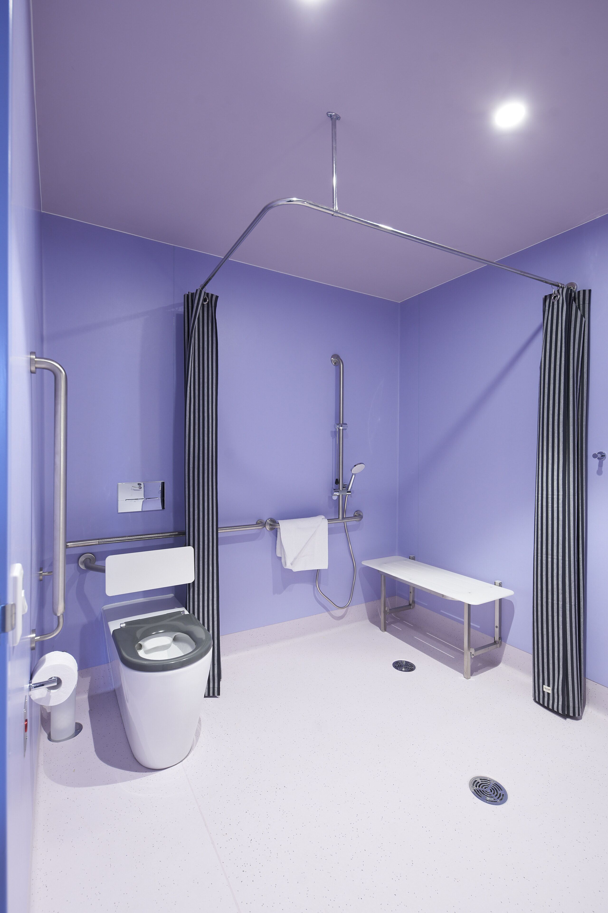 A modern bathroom with a shower, toilet, and sink.