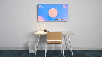Un espacio de trabajo moderno con un escritorio, una silla y un monitor de computadora montado que muestra un calendario.