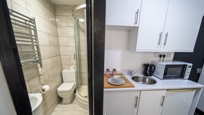 A compact bathroom with a toilet, shower, and sink. - Studio available close to Queen Elizabeth Hospital (Birmingham)