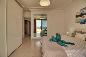 A hotel room with a bed, a view of the balcony, and a painting on the wall. - Penthous 2 Bed room - Jacuzzi - Terrace - Pool (Costa Adeje)