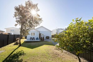 Enjoy a peaceful retreat in this serene home surrounded by a lush yard and a shaded porch.