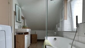 A modern bathroom with a freestanding bathtub, a glass shower enclosure, and a wooden vanity. - Apartment "Dreams im Obergeschoss" with Private Terrace & Wi-Fi (Kötz)