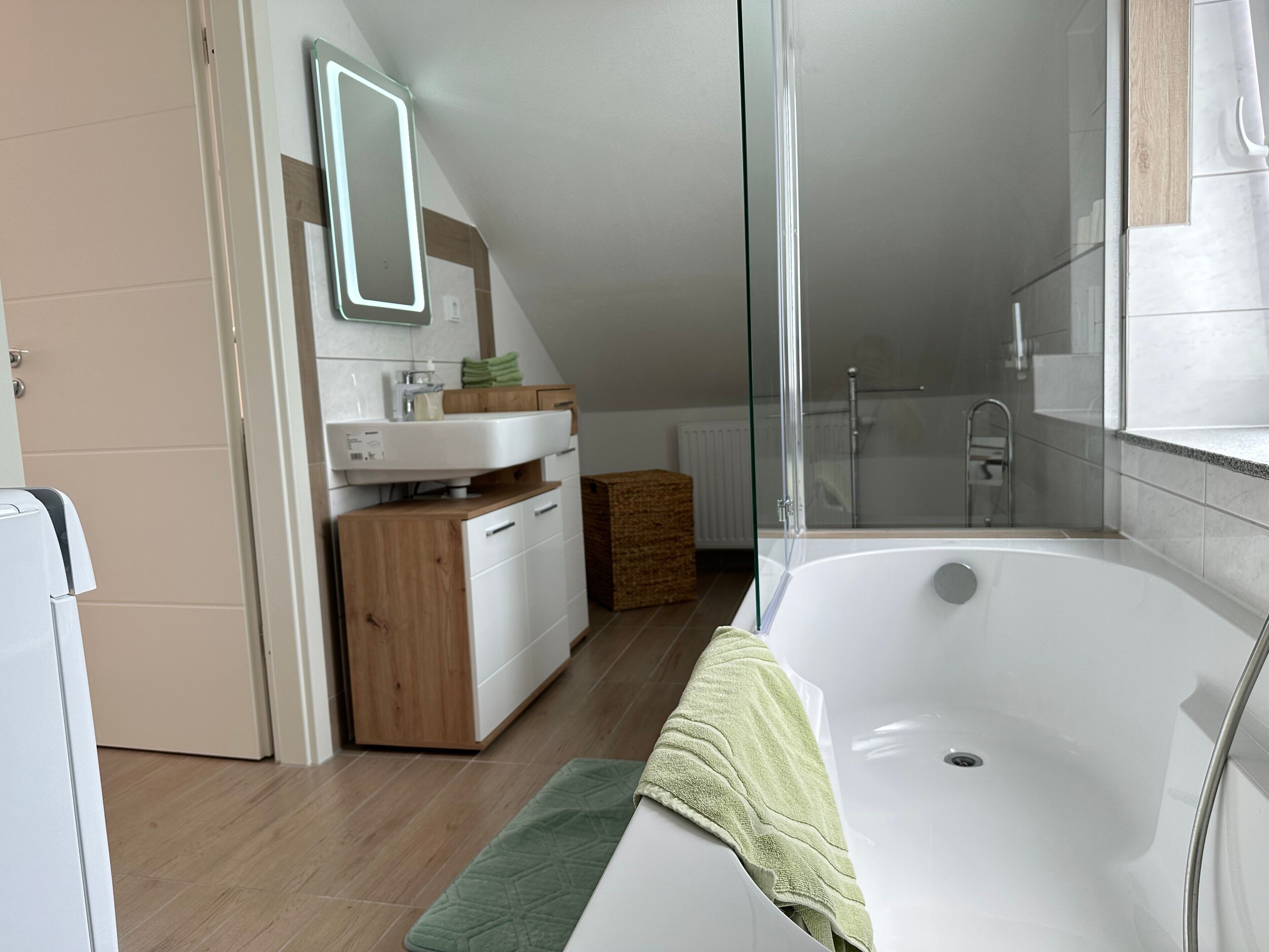 A modern bathroom with a bathtub, a shower, and a glass-enclosed shower area.