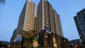 A modern high-rise building with a prominent entrance labeled 'UH FLAT.' - UH FLAT THE SEOCHO (Seoul)