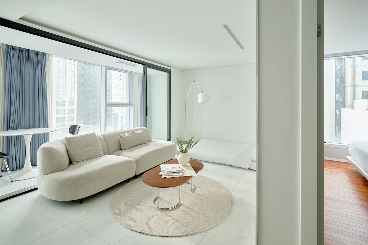 A modern living room with a sofa, a coffee table, and a lamp.