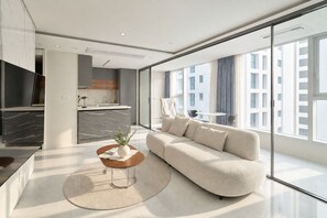 A modern living room with a sofa, a coffee table, and a TV. - UH FLAT THE SEOCHO (Seoul)