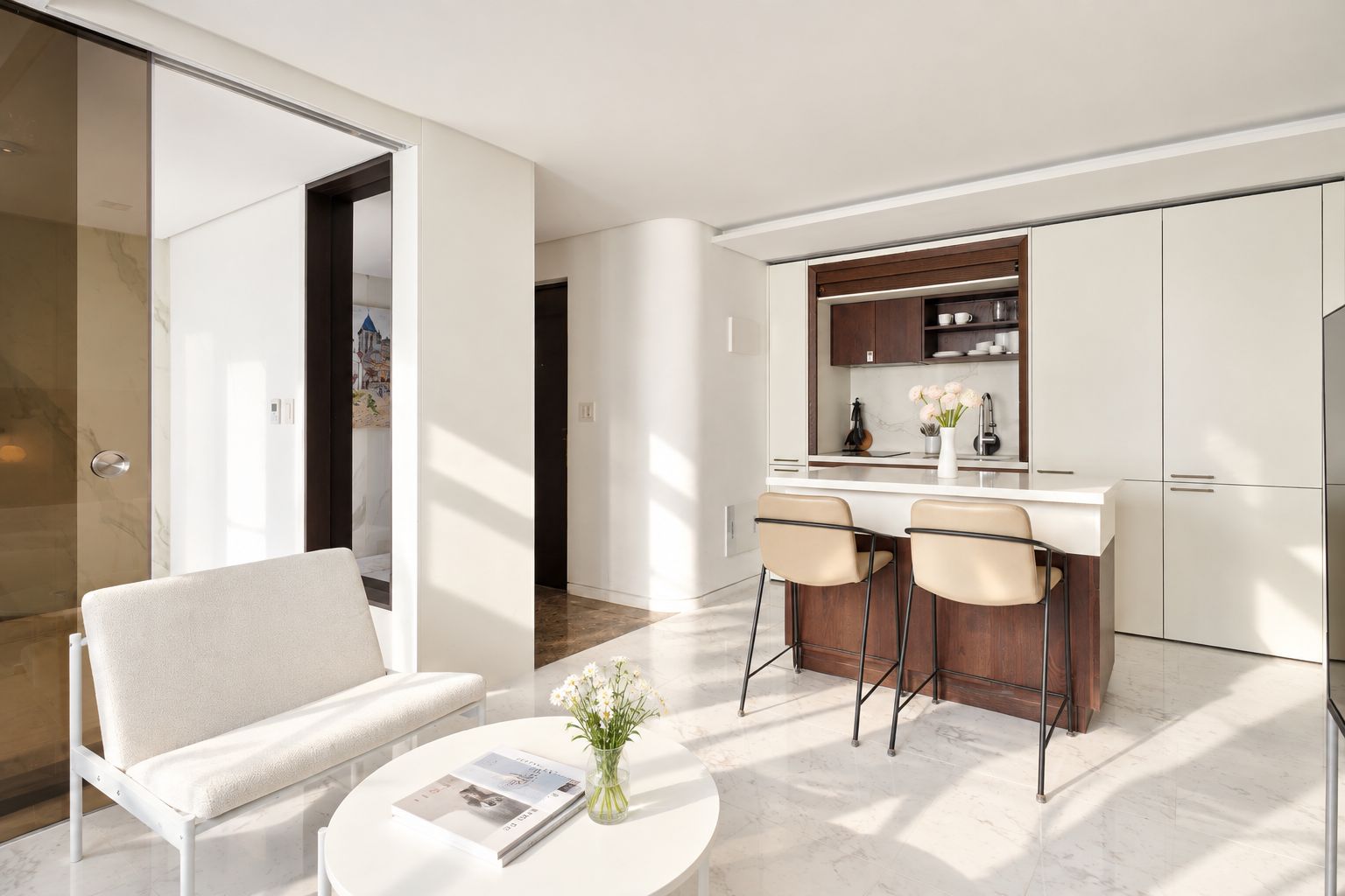 Una cocina moderna con barra, un sofá blanco y una mesa de centro con una revista y flores.