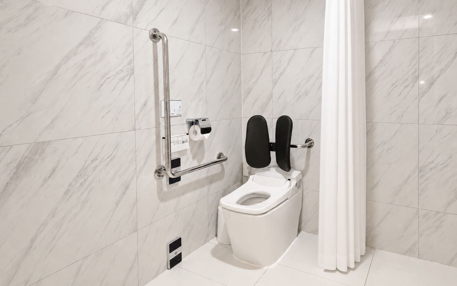 Un baño moderno con inodoro blanco, barra de apoyo y cortina de ducha.