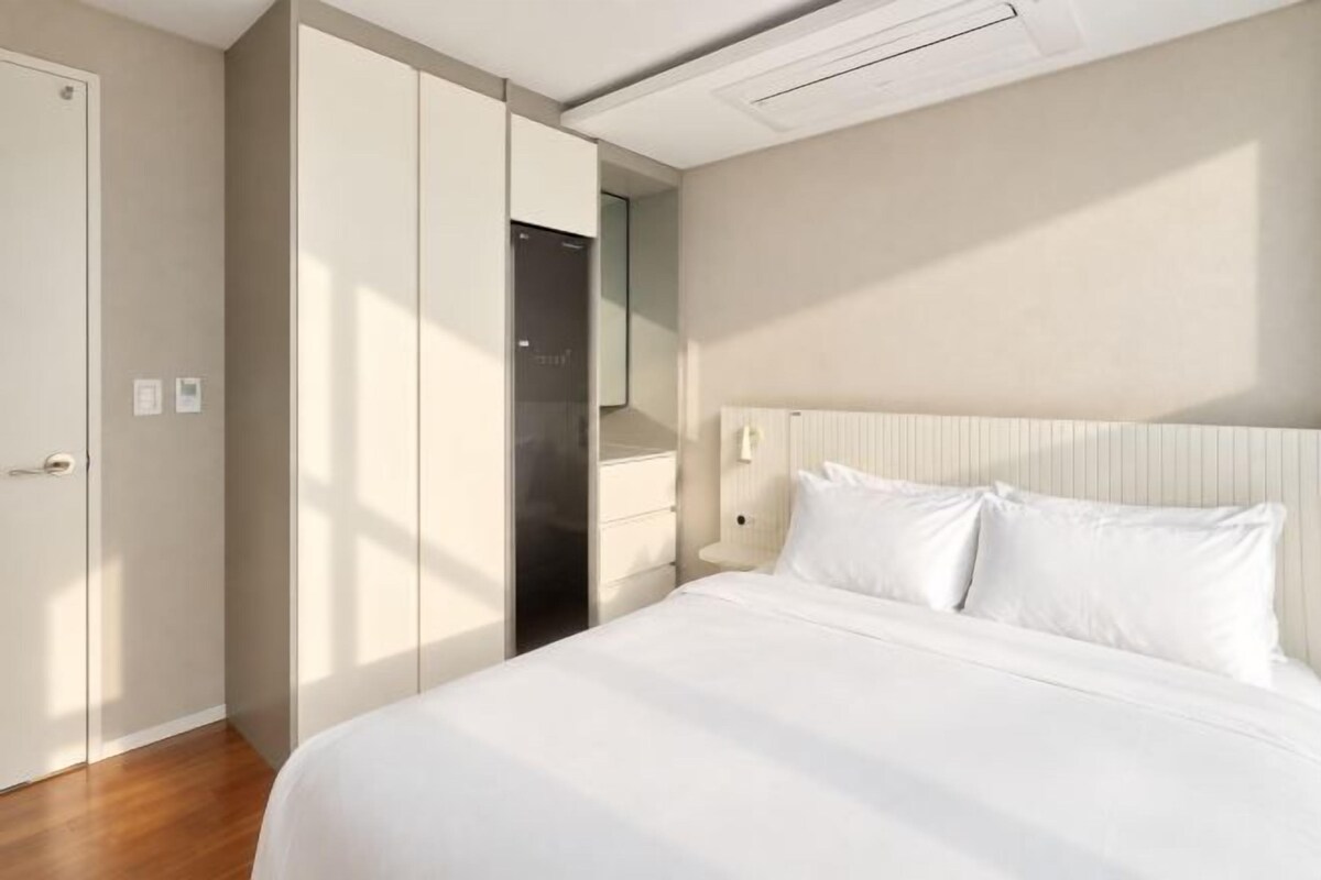 A hotel room with a bed, a wardrobe, and a nightstand.