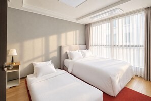 A hotel room with two beds, a nightstand, a lamp, and a large window with curtains. - UH FLAT THE SEOCHO (Seoul)