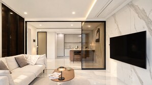 A modern living room with a sofa, coffee table, and a TV mounted on the wall. - UH FLAT THE SEOCHO (Seoul)