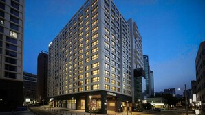 A high-rise hotel with a modern design, multiple floors, and a prominent entrance. - UH FLAT THE SEOCHO (Seoul)
