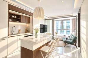 A modern kitchen with a marble countertop, built-in wooden shelves, and a pendant light. - UH FLAT THE SEOCHO (Seoul)