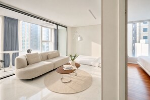 A modern living room with a sofa, coffee table, and a view of the city through large windows. - UH FLAT THE SEOCHO (Seoul)