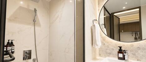 A modern bathroom with a shower, a sink, and a mirror.