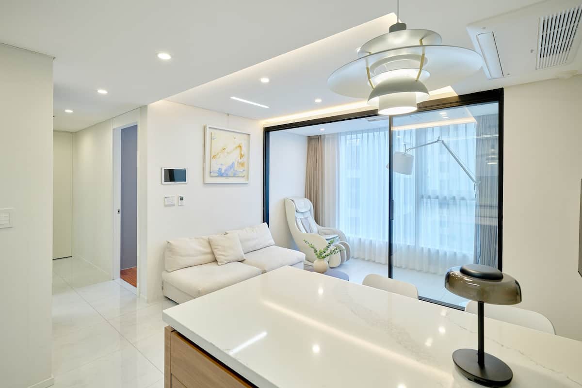 A modern living room with a white sofa, a coffee table, and a floor lamp.