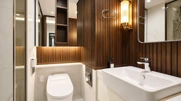 Un baño moderno con inodoro, lavamanos y zona de ducha.