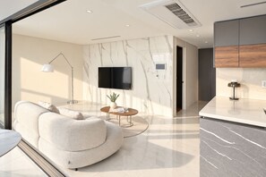 A modern living room with a sofa, a coffee table, a TV, and a floor lamp. - UH FLAT THE SEOCHO (Seoul)