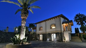 A two-story house with a stone facade, arched windows, and a balcony. - Villa Biddizza 10 Emma Villas (Acireale)