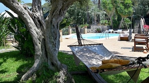 A hammock under a tree, a pool, and outdoor seating. - Villa Biddizza 10 Emma Villas (Acireale)