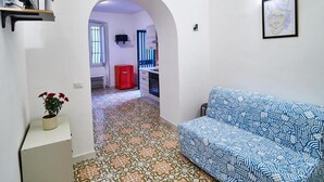 A compact living space with a kitchenette, a sofa, and a small dining area. - Appartamento a Vietri sul Mare ID 4144 (Vietri sul Mare)
