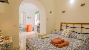 A bedroom with a bed, a desk, and a kitchenette. - Appartamento a Vietri sul Mare ID 4144 (Vietri sul Mare)