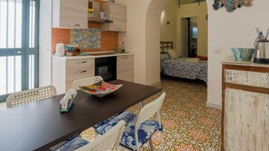 A compact living space with a kitchen, dining area, and bedroom. - Appartamento a Vietri sul Mare ID 4144 (Vietri sul Mare)