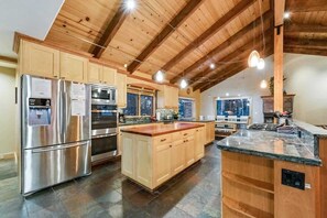A spacious kitchen with wooden cabinets, stainless steel appliances, and a large island.
