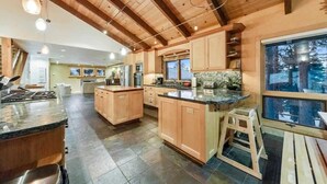 Una cocina amplia con armarios de madera, una isla grande y vistas al exterior a través de una ventana.