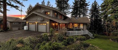 A two-story house with a garage, a covered porch, and a well-maintained garden.