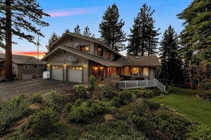 A two-story house with a garage, a covered porch, and a well-maintained garden.