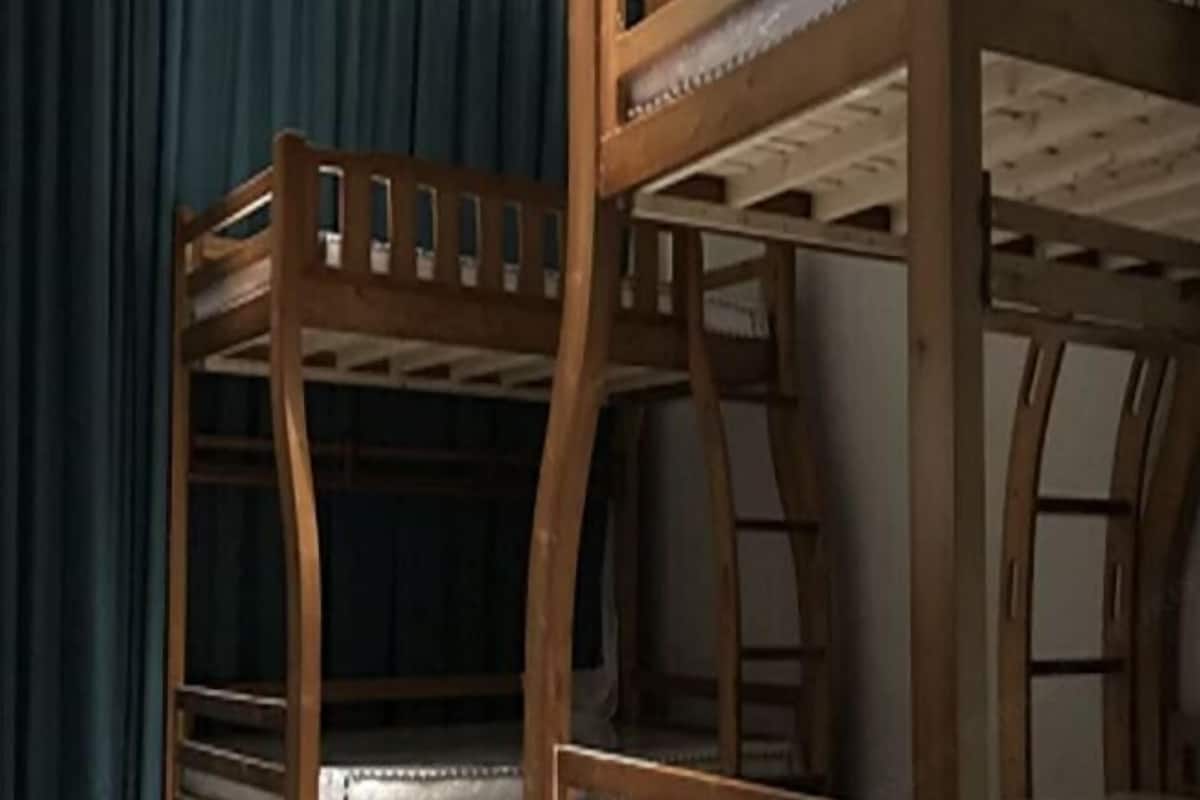 A bunk bed with a wooden frame and slatted headboard.