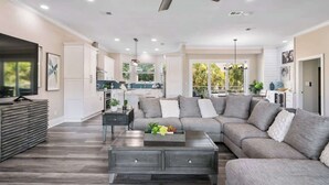 A spacious living room with a sectional sofa, a coffee table, and a ceiling fan. - Coastal Villas (Destin)