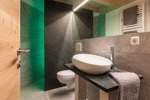Ein modernes Badezimmer mit Waschbecken, Handtuch und Toilette.