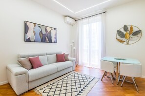 A modern living room with a sofa, a dining table, and artwork on the walls. - Stanzione Classy Flat at Vomero Central (Naples)