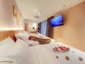 A hotel room with two beds, a TV, a desk, and a mirror. - Sleep Box Penang (George Town)