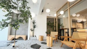 A modern interior with a seating area, wooden furniture, and a 'SLEEP BOX' sign. - Sleep Box Penang (George Town)