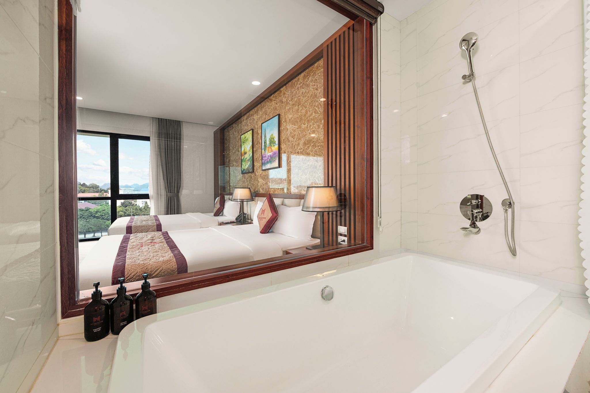 Habitación de hotel con una bañera grande, dos camas, una ventana con vistas y zona de ducha.