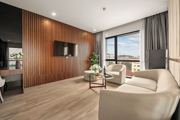 Uma sala de estar moderna com uma parede de destaque em madeira, uma televisão de tela plana, um sofá, uma mesa de centro e vista para a cidade.